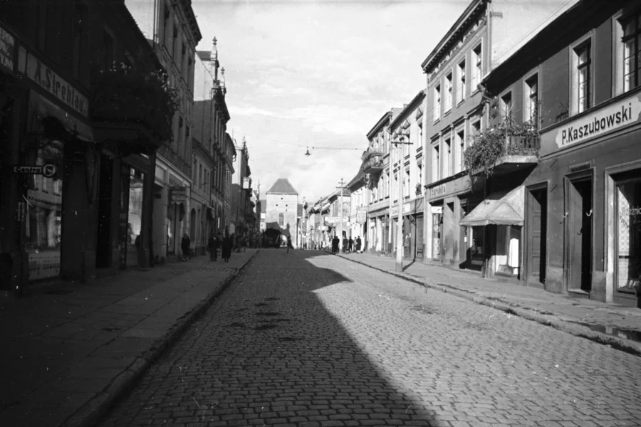 Ulica Grudziądzka wraz z Bramą Grudziądzką. Ludzie na ulicy (Narodowe Archiwum Cyfrowe)